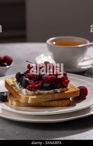 Toast mit frischen Heidelbeeren, Himbeeren, roten Johannisbeeren und Ricotta-Käse Stockfoto