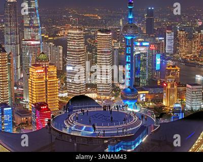 Shanghai, China. April 2025. Ein Drohnenfoto zeigt Besuchern, die das Stadtbild bei The Stage, einer neuen Aussichtsplattform auf der White Magnolia Plaza in Shanghai, Ostchina, am 14. April 2025 genießen. Die Aussichtsplattform wurde am Dienstag für die Öffentlichkeit geöffnet und bietet Besuchern einen 360-Grad-Panoramablick auf die 320 Meter hohe Innenstadt von Shanghai. Quelle: Liu Ying/Xinhua/Alamy Live News Stockfoto