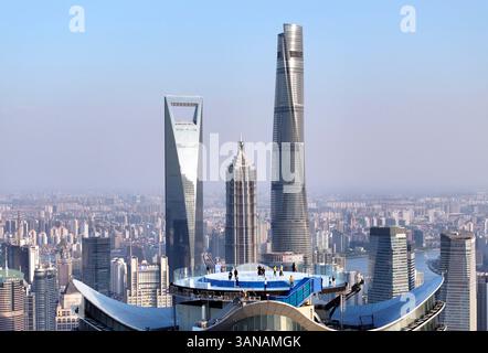 Shanghai, China. April 2025. Ein Drohnenfoto zeigt Besuchern, die das Stadtbild bei The Stage, einer neuen Aussichtsplattform auf der White Magnolia Plaza in Shanghai, Ostchina, am 14. April 2025 genießen. Die Aussichtsplattform wurde am Dienstag für die Öffentlichkeit geöffnet und bietet Besuchern einen 360-Grad-Panoramablick auf die 320 Meter hohe Innenstadt von Shanghai. Quelle: Liu Ying/Xinhua/Alamy Live News Stockfoto