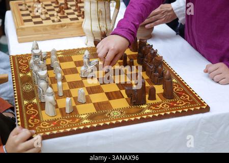 Kinder spielen ein Spiel handgemachter Schach Stockfoto