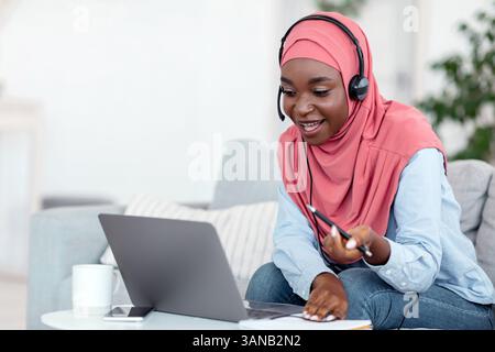 Online-Tutoring. Freundliche schwarze muslimische weibliche Tutor mit Videoanruf mit Studenten Stockfoto