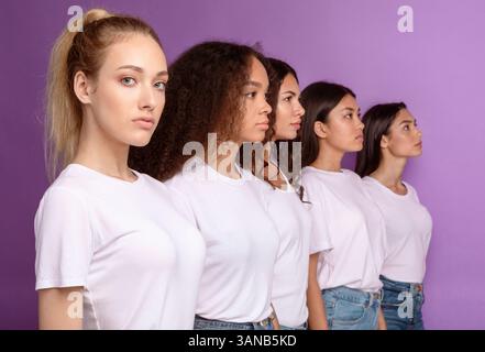 Gruppe Ernsthafter Multikultureller Frauen, Die In Reihe Stehen, Lila Hintergrund Stockfoto