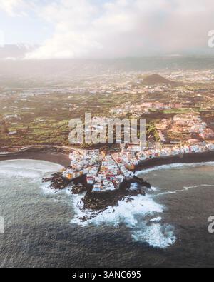 Blick aus der Vogelperspektive auf das malerische Dorf Punta Brava mit wunderschönen Wohnhäusern entlang der Küste und ruhigen Meereswellen, Puerto la Cruz, Spanien. Stockfoto