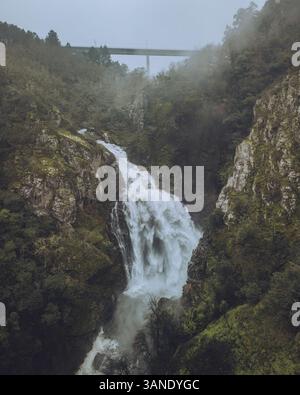 Aus der Vogelperspektive auf den wunderschönen Wasserfall Fervenza do Toxa, der durch einen üppigen Wald und felsige Klippen fällt, Silleda, Pontevedra, Spanien. Stockfoto