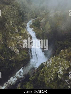 Aus der Vogelperspektive auf den majestätischen Wasserfall Fervenza do Toxa, der durch üppiges Grün und felsige Klippen fällt, Silleda, Pontevedra, Spanien. Stockfoto