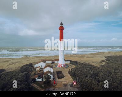 Blick aus der Vogelperspektive auf den malerischen Leuchtturm von La Coubre entlang der ruhigen Küste mit Sandstrand und Dünen, La Tremblade, Charente-Maritime, Frankreich. Stockfoto