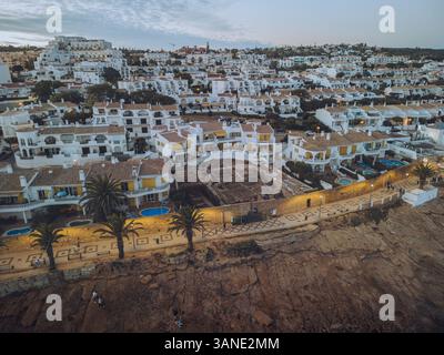 Aus der Vogelperspektive von praia da luz mit weiß getünchten Häusern und Palmen bei Sonnenuntergang, Faro, Portugal. Stockfoto