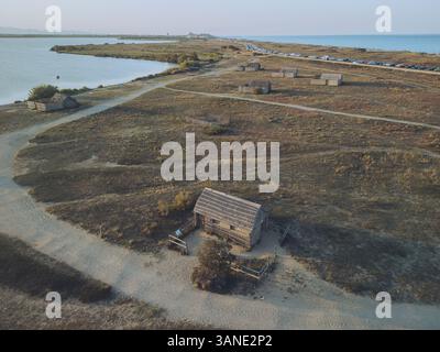 Aus der Vogelperspektive auf etang de Canet et de Saint-Nazaire mit rustikalen Fischerhütten und ruhigem Wasser, Canet-en-Roussillon, Frankreich. Stockfoto