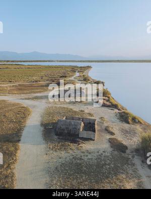 Aus der Vogelperspektive auf etang de Canet et de Saint-Nazaire mit ruhigen Fischerhütten und ruhigem Wasser, Canet-en-Roussillon, Frankreich. Stockfoto