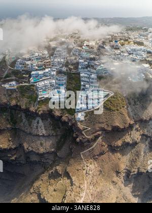 Vertikaler Blick über die Wolken traditioneller weißer Häuser auf der Insel Santorin, Griechenland. Stockfoto