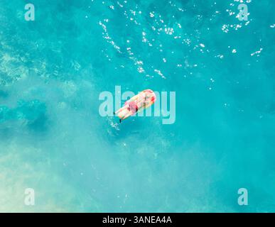 Luftaufnahme eines Mannes, der auf aufblasbarem Strand schwimmt, Griechenland. Stockfoto