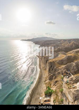 Blick aus der Vogelperspektive auf den Strand mit felsiger Küste entlang der Insel Santorin, Griechenland. Stockfoto