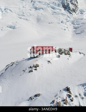 Aus der Vogelperspektive auf die rote Mueller Hut in den verschneiten Bergen von Aoraki, Mount Cook National Park, Südinsel, Neuseeland. Stockfoto