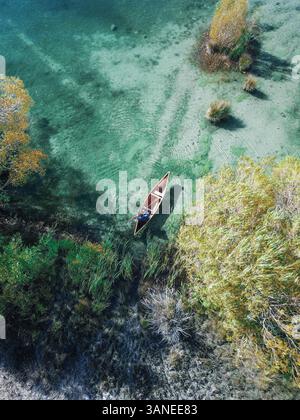 Blick aus der Vogelperspektive auf das klassische kanadische Kanufahren auf einem kleinen Teich mit Schilf und Büschen in Tekapo, Südinsel, Neuseeland Stockfoto