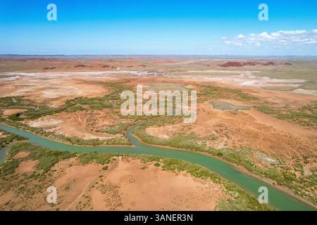 Aus der Vogelperspektive zieht sich der cleaverville Creek durch karge Wüstenlandschaft unter blauem Himmel, cleaverville, West australia. Stockfoto