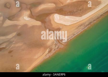 Blick aus der Vogelperspektive auf den ruhigen Nullagine River, der sich durch die riesige Pilbara Region mit wunderschönem türkisfarbenem Wasser und einer Küstenlinie schlängelt, Cossack, Australien. Stockfoto