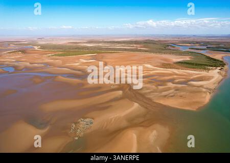 Aus der Vogelperspektive auf den sich windenden Nullagine River durch eine weite, trockene Landschaft mit rauem Gelände und schönem Himmel, Cossack, Australien. Stockfoto