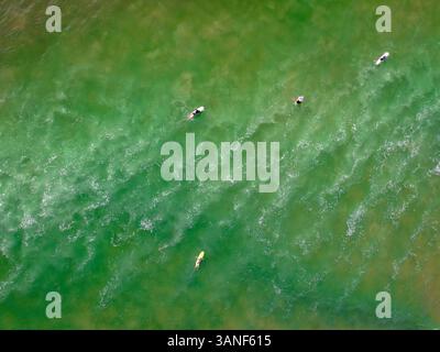 Aus der Vogelperspektive auf Surfer, die am Little Cove Beach, Noosa Heads, Australien, Wellen fangen. Stockfoto
