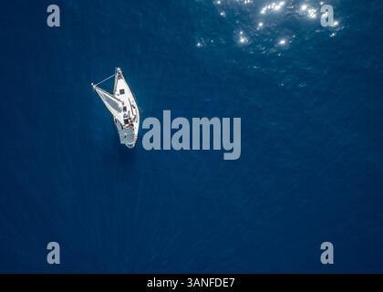 Aus der Vogelperspektive eines kleinen Segelbootes, das im ruhigen Wasser des Mittelmeers vor der spanischen Küste segelt. Spanien. Stockfoto