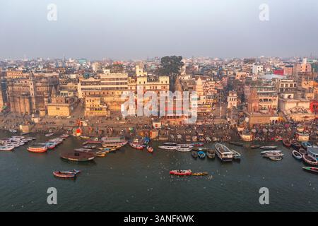 Blick aus der Vogelperspektive auf den belebten Ganges mit farbenfrohen Ghats und Booten, Varanasi, Uttar Pradesh, Indien. Stockfoto