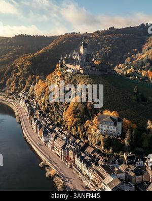 Blick aus der Vogelperspektive auf die malerische mittelalterliche Reichsburg mit Blick auf die ruhige Mosel mit herbstlichen Hügeln und die charmante Stadt Cochem, Deutschland. Stockfoto