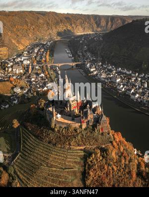 Blick aus der Vogelperspektive auf die malerische mittelalterliche Reichsburg mit Blick auf die ruhige Mosel mit herbstlichen Hügeln und die charmante Stadt Cochem, Deutschland. Stockfoto