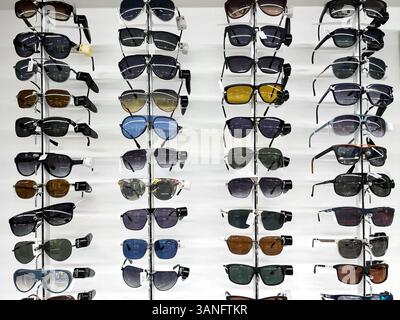 Ausstellung einer Reihe von Sonnenbrillen auf einem Regal in einem optischen Geschäft. Dubai, VAE, 12. April 2025 Stockfoto