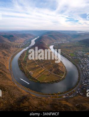 Aus der Vogelperspektive auf die sich schlängelnde Mosel mit Schiffen und malerischen Hügeln im Herbst, Bremm, Rheinland-Pfalz, Deutschland. Stockfoto