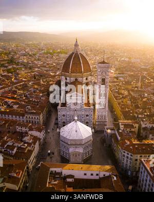 Blick aus der Vogelperspektive auf die berühmte Kathedrale Santa Maria del Fiore bei Sonnenaufgang mit farbenfrohen Dächern und mittelalterlichen Türmen, Florenz, Italien. Stockfoto