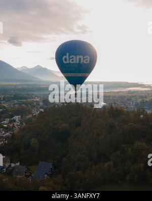 Aus der Vogelperspektive des Heißluftballons bei Sonnenaufgang über dem ruhigen Bleder See und den majestätischen Julischen Alpen, Bled, Slowenien. Stockfoto