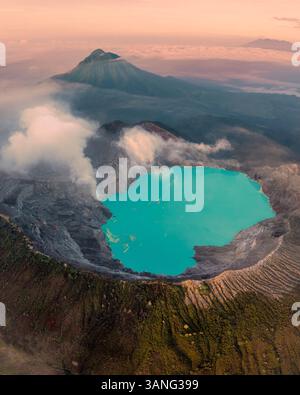 Aus der Vogelperspektive auf den Kawah Ijen Vulkan mit einem wunderschönen See und Rauch bei Sonnenaufgang, Java, Indonesien. Stockfoto