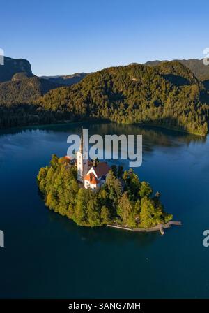 Drohnenansicht der Kirche auf einer kleinen Insel mitten im Bleder See, Slowenien. Stockfoto