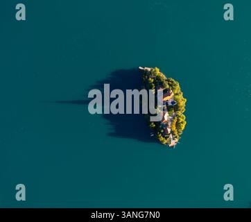 Luftdrohne Blick von oben auf die Kirche auf einer kleinen Insel in der Mitte des Bleder Sees, Slowenien. Stockfoto