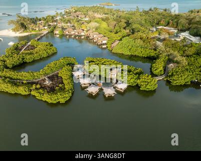 Blick aus der Vogelperspektive auf das luxuriöse Inselresort mit Bungalows und einer ruhigen Lagune, umgeben von tropischem Grün, Prinz maurice, flacq, mauritius. Stockfoto