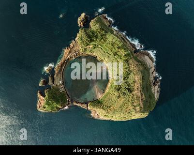 Aus der Vogelperspektive der abgelegenen üppigen Insel mit vulkanischem Krater und felsiger Klippe, Ilheu de Vila Franca de Campo, Portugal. Stockfoto