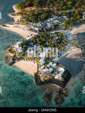 Flacq, Mauritius - 12. Oktober 2022: Blick aus der Vogelperspektive auf ein Resort-Hotel mit privatem Strand entlang der Küste bei Sonnenuntergang, Ilot Lievres. Stockfoto