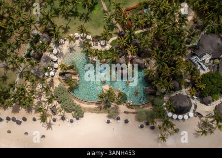 Blick aus der Vogelperspektive auf ein luxuriöses Resort mit Swimmingpool am Strand Flic EN FLAC, eine tropische Oase und Reiseziel in Riviere Noire, Mauritius. Stockfoto