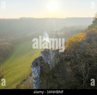 Aus der Vogelperspektive einer Frau, die auf den Felsen steht, mit Walzschloss im Hintergrund bei Sonnenuntergang, Dinant, Namur, Belgien. Stockfoto