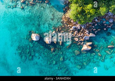 Aus der Vogelperspektive auf die felsige Küste in der Nähe von Anse Lazio Beach, Grand Anse, Seychellen. Stockfoto
