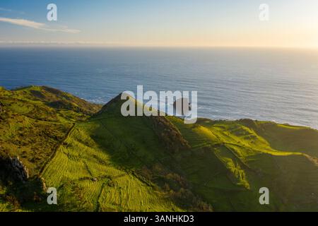 Aus der Vogelperspektive auf den Bergrücken entlang der Küste in der Nähe von Cascata da Ribeira do Fundao, Ilha das Flores, Azoren Inseln, Portugal. Stockfoto