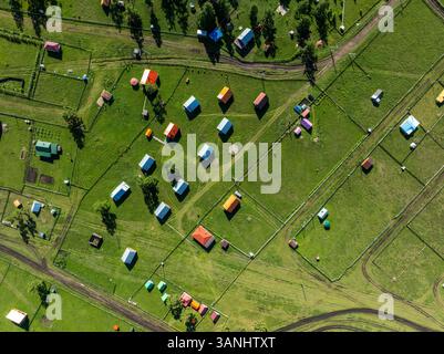 Aus der Vogelperspektive auf ein ruhiges Dorf mit bunten Dächern und grünen Feldern im Altai-Gebirge, Bayan-Ondor, Mongolei. Stockfoto