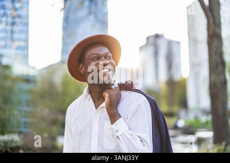 Porträt eines gutaussehenden Mannes mit Hut in der Stadt Stockfoto