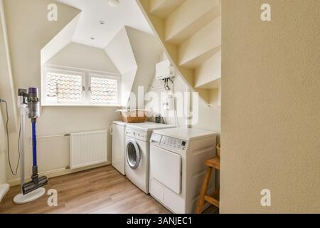 Ein stilvoller und effizienter Waschraum mit Waschmaschine, Trockner und viel Stauraum, der auf Funktionalität und moderne Ästhetik ausgelegt ist. Stockfoto