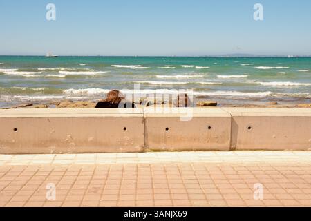 Ein Paar sitzt und blickt von Les Meravelles, Insel Mallorca, Spanien über die Bucht von Palma Stockfoto