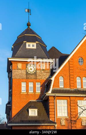 Späte Nachmittagssonne über dem Uhrenturm des Rathauses in Papenburg Stockfoto