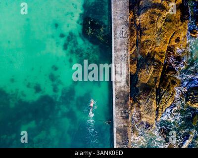 Aus der Vogelperspektive einer Person, die im Gezeitenpool Camps Bay schwimmt, Kapstadt, Südafrika. Stockfoto