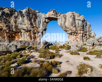 Luftaufnahme einer Frau in roter Jacke bei Wolfberg Arch Hiking, Western Cape, Südafrika. Stockfoto