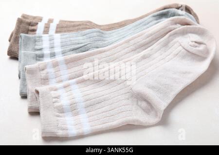 Verschiedene weiche Socken auf hellbeigem Hintergrund, Nahaufnahme Stockfoto