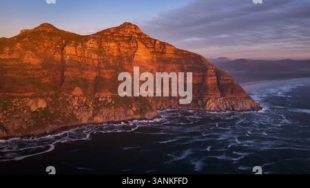 Aus der Vogelperspektive auf den Küstenberg mit Wellen, die gegen felsige Klippen stürzen, Chapmans Peak, Western Cape, Südafrika. Stockfoto