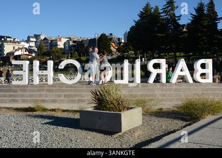 Touristen posieren für ein Foto neben einem Schild mit dem Namen der Stadt Bariloche in der argentinischen Region Patagonien. Stockfoto